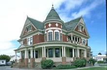 терракотовый викторианский дом с террасой и двумя фронтонами